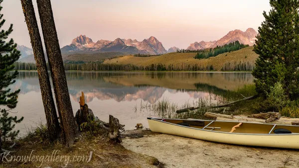Canoe parked on the shore of an Idaho mountain lake at sunrise